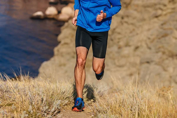 Mavi Ceketli Siyah Taytlı Kuru Otlarla Dağlarda Koşan Bir Koşucu — Stok fotoğraf
