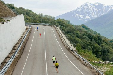 Yol dağları maratonunda yokuş yukarı koşan bir grup sporcusu