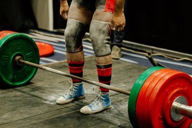 Dizlik ve spor talk pudralı bacak kaldırıcı Deadlift yarışmasında ön halterde durun.