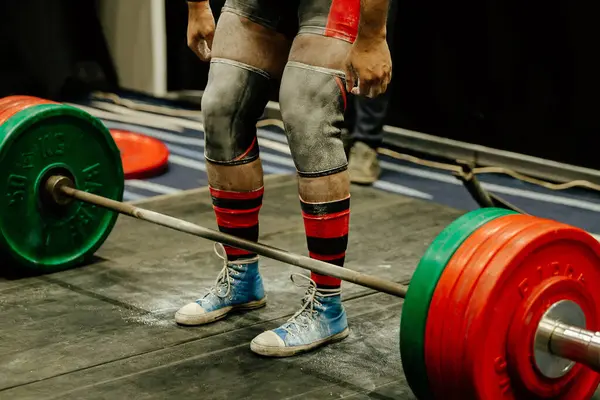 Dizlik ve spor talk pudralı bacak kaldırıcı Deadlift yarışmasında ön halterde durun.