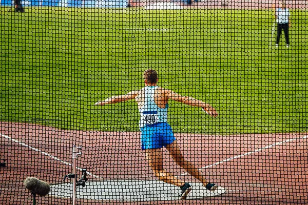 stock image discus throw, male athlete makes an attempt, view through grid