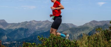 Kadın koşucu dik yamaç dağ maratonu koşusu yapıyor.