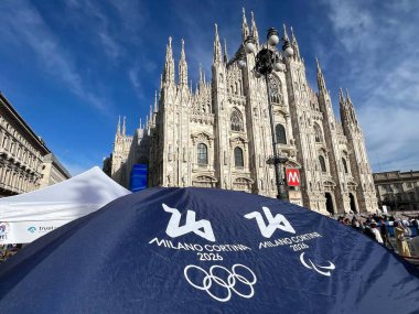 Milan, italy - September 14, 2024: official logo Olympic games in Milan and Cortina 2026 on background of Cathedral Duomo clipart