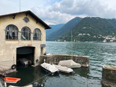 House with boat parking arrangement in basement on lake Como clipart