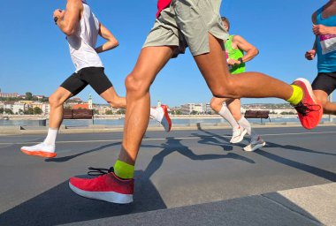 Grup üyesi atlet nehir kenarında maraton koşuyor.