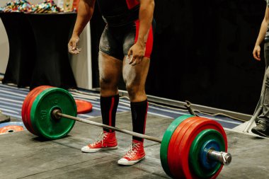 Power lifter halterin önünde duruyor ve kaldırmaya hazırlanıyor.