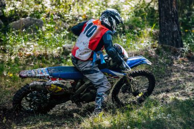 Orman yolunda giden off-road motosikletçisi