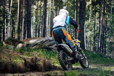 Orman yolunda arkadan yakalanan off-road motosikletçisi.