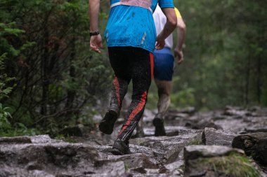 Şiddetli yağmurda maraton sırasında çamurlu taş koşan arka manzara sporcusu