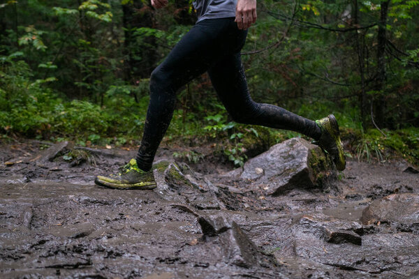 Ноги спортсмена, бегущего грязь и камни во время лесного марафона