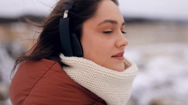 Açık Havada Yürürken Müzik Dinlerken Kameraya Gülümserken Kulaklık Takan Güzel — Stok video