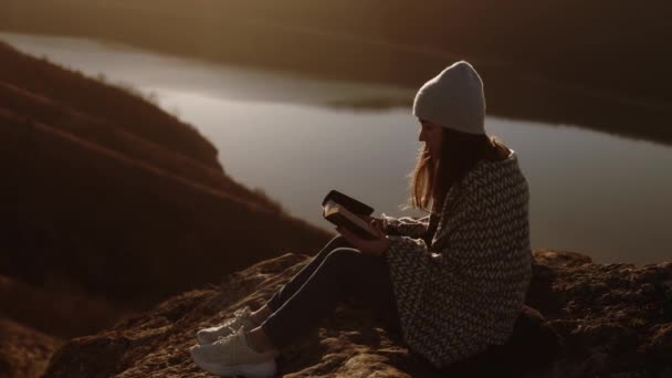 Young Beautiful Woman Wrapped Blanket Reading Bible Sitting Top Rock — Video