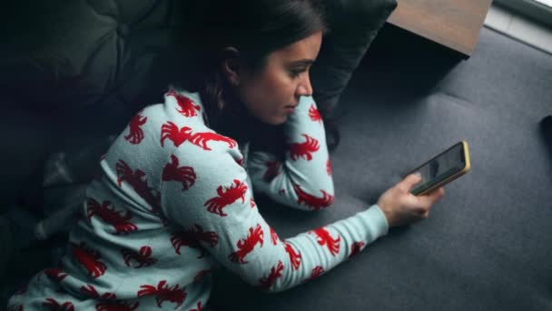 Genç Güzel Bir Kadın Kanepede Uzanıyor Akıllı Telefon Kullanıyor Haberlerde — Stok video