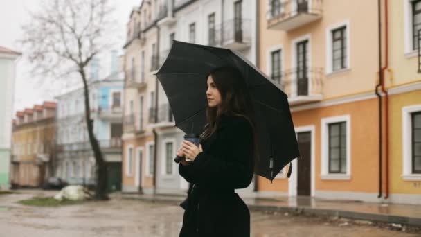 Yağmurda Şehir Caddesinde Elinde Siyah Bir Şemsiye Bir Fincan Kahveyle — Stok video