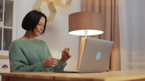 Женщина Средних Лет Держащая Кредитную Карту Используя Ноутбук Делает Интернет — стоковое видео