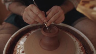 Close up top view Man potter working on potter's wheel making ceramic pot from clay in pottery workshop, creativity, hobby and workshop. High quality 4k footage