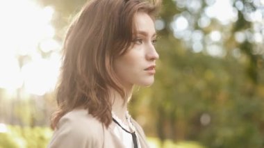 Young beauty touching her beautiful brunette hair and looking at the camera. Happy female models posing outdoor. It looks wonderful and charming. It has a good appearance. Stylish and elegant