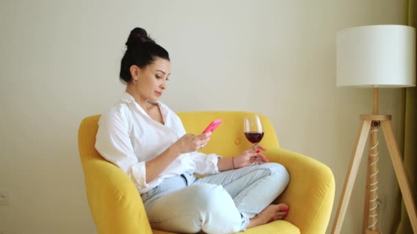 Ung Smuk Kvinde Sidder Hjemme Behagelig Stol Drikker Vin Bruger – Stock-video