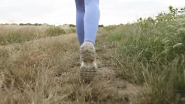 Young slim woman running to the top of a mountain peak at sunrise, raising her hands in the air, happy and drunk with the life, youth and happiness, beautiful view, reaching the peaks