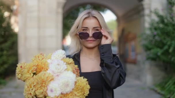 Beautiful Blonde Girl Puts Sunglasses Smiling Holding Bouquet Flowers Walking — Video Stock