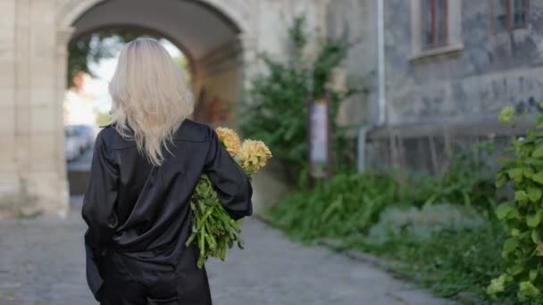 Привлекательная Молодая Женщина Идущая Улице Букетом Цветов Поворачивающаяся Назад Распущенными — стоковое видео