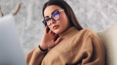Ofiste dizüstü bilgisayarla çalışan, kendine güvenen, gözlüklü genç bir iş kadınının yakın plan portresi. Teknoloji, ticaret ve finans kavramı, ekonomi, yönetim, başarı, öğrenci ve programcı