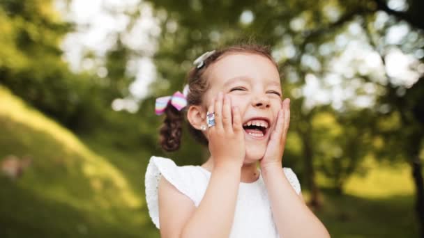 Chica Feliz Sonríe Con Fuerza Sostiene Sus Palmas Sus Mejillas — Vídeos de Stock