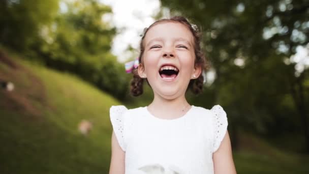 Πορτρέτο Ενός Μικρού Ευτυχισμένου Κοριτσιού Που Γελάει Δυνατά Ακούγοντας Ένα — Αρχείο Βίντεο