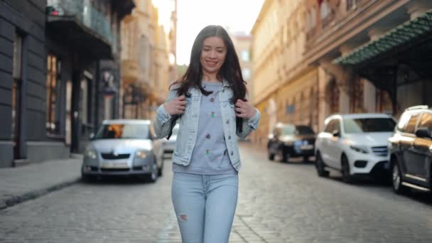 Μια Νεαρή Χαμογελαστή Γυναίκα Περπατάει Ένα Δρόμο Της Πόλης Ένα — Αρχείο Βίντεο