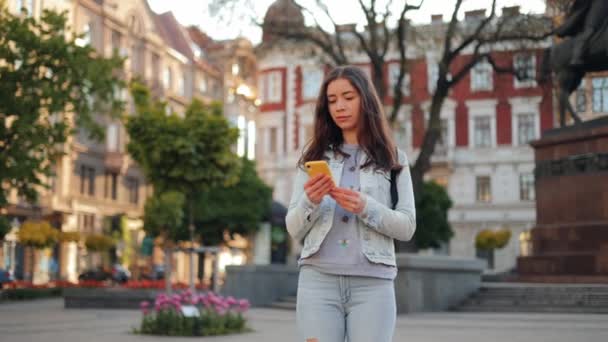 Atractiva Mujer Ucraniana Con Una Mochila Utiliza Teléfono Inteligente Mientras — Vídeo de stock