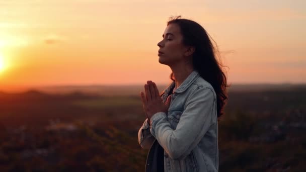 日落时 女孩双手交叉在一起祈祷 站在室外祈祷的女人 慢动作视频 一个女人向上帝祈祷 祈求世界上的罪与和平 — 图库视频影像