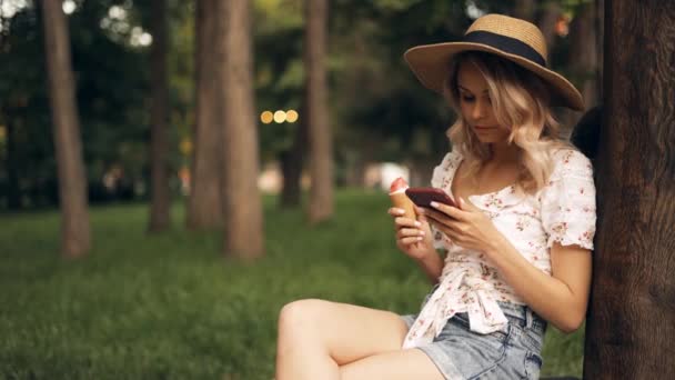 Νεαρή Ελκυστική Γυναίκα Ψάθινο Καπέλο Κάθεται Στον Πάγκο Στο Πάρκο — Αρχείο Βίντεο
