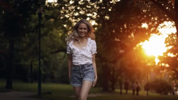 Atrakcyjna Młoda Kobieta Spacerująca Parku Odwracająca Się Luźnymi Włosami Patrząca — Wideo stockowe