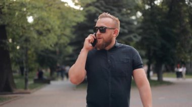 Mutlu sakallı bir iş adamı şehirde dolanıyor, cep telefonuyla konuşuyor, bir iş davasını çözüyor.