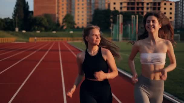 Две Красивые Девушки Бегают Закате Городском Стадионе Молодые Кавказские Женщины — стоковое видео