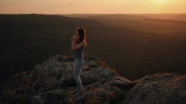 Genç bir kadın, kulaklıkla müzik dinlerken bir dağda dans ederken inanılmaz bir manzarası olan, dans ederken, şarkı söylerken, yürürken ya da seyahat ederken en sevdiği şarkının tadını çıkarırken.