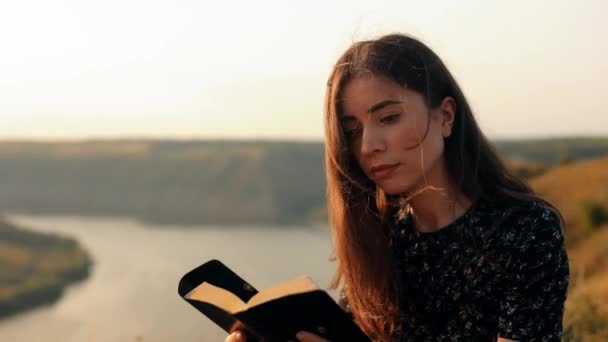 一个年轻貌美的女子在日落时在户外细心地阅读圣经的特写 — 图库视频影像