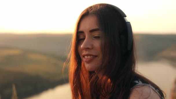 Portrét Turistické Dívky Sluchátkách Usmívající Kamery Vrcholu Skály Při Západu — Stock video
