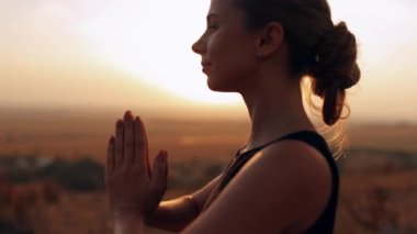 Temiz hava soluyan güzel genç bir kadın dışarıda özgürlüğü ya da mutluluğu hissediyor. Barışçıl bir kadının meditasyon yaptığı, rahatlamak için yoga yaptığı, hafta sonunun tadını çıkardığı yakın plan fotoğrafları.