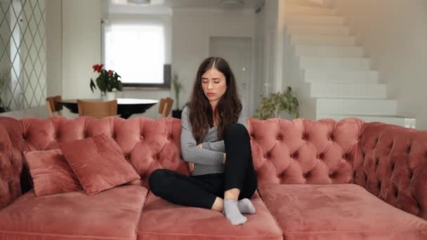 Seorang Wanita Menawan Memiliki Sakit Perut Memeluk Perutnya Duduk Sofa — Stok Video