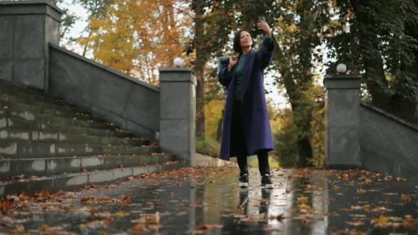 Güzel Orta Yaşlı Şık Montlu Bir Kadın Sonbahar Parkında Yürürken — Stok video