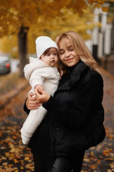 Doğanın arka planında poz veren küçük kızı tutan mutlu kadın. Aile yaşam tarzı konsepti. Annelik. Sonbahar sezonu. Kız ve anne birlikte portre