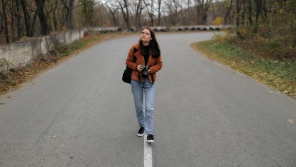 Молода Приваблива Жінка Рюкзаком Камерою Йде Красивій Дорозі Лісом Подорожуючи — стокове відео