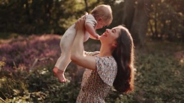 Mutlu bir anne gün batımında yaban çiçeği çayırında küçük çocuğuyla oynuyor. Bir kadın oğlunu kaldırır, öper ve ona sarılır. Mutlu tasasız annelik