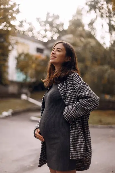 Genç, modaya uygun bir annenin portresi. Bokeh ile sonbahar geçmişi. Fotoğraf sonbaharın sonlarında çekildi..