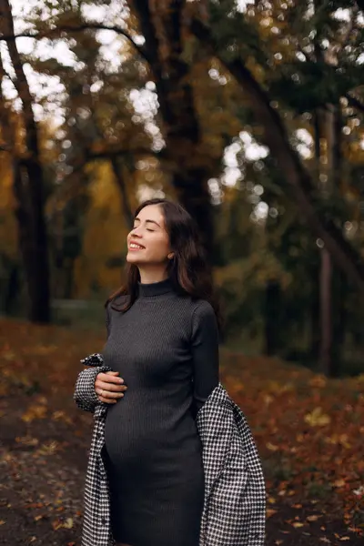 Genç hamile kadına sonbahar parkta poz görüntülemek