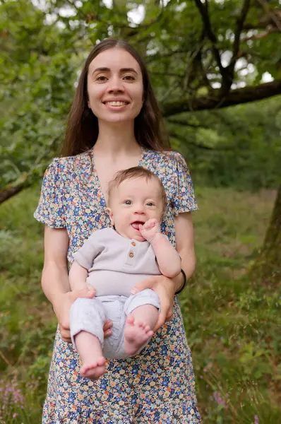 Anne ve bebeğin portresi. Doğal annelik ve annelik kavramı. Güzel kadın ve küçük bebek yeşil doğada birlikte mutlular. Dışarıda çocuklu bir anne..