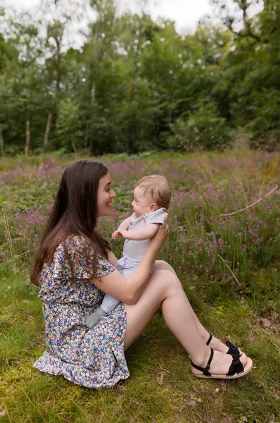 Anne ve bebek. Doğal annelik ve annelik kavramı. Güzel kadın ve küçük bebek yeşil doğada birlikte mutlular. Dışarıda çocuklu bir anne..