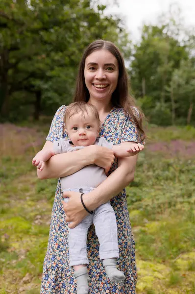 Baharda ya da yaz bahçesinde Mutlu kadın ve çocuk portresi. Anne ve oğul oynuyorlar, sarılıyorlar ve gülümsüyorlar. Aile tatili ve birliktelik