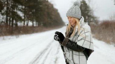 Karlı bir tarlanın ortasında ya da kar altında bir parkta duran, karla oynayan, kameraya büyüleyici bir şekilde gülümseyen çekici genç bir kız. Noel tatili.